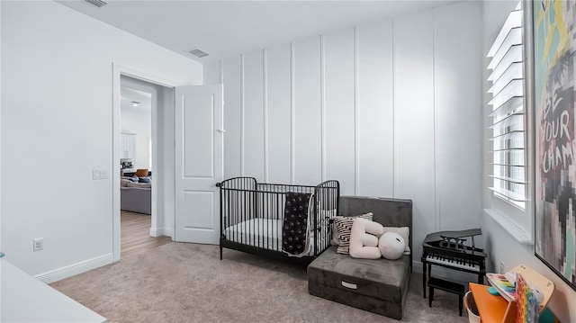 carpeted bedroom featuring a crib