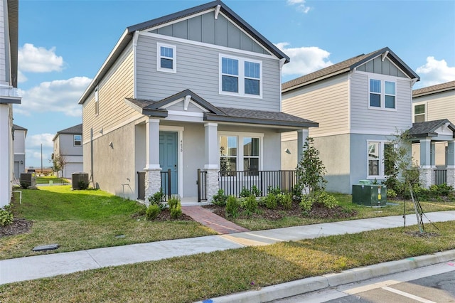 craftsman-style home featuring central AC, a front lawn, and covered porch