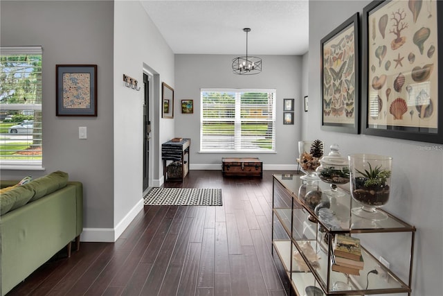 interior space with dark wood-type flooring and a chandelier