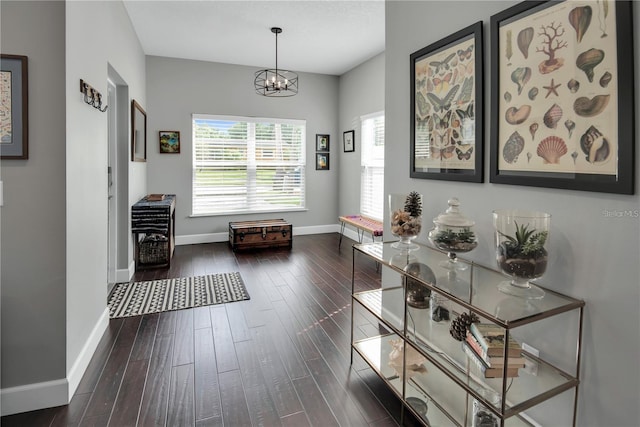 interior space featuring dark wood-type flooring and an inviting chandelier