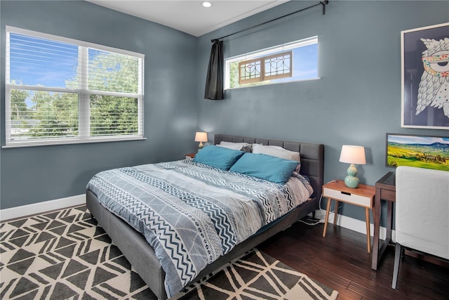 bedroom with multiple windows and dark hardwood / wood-style flooring