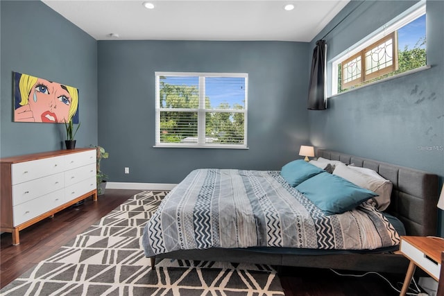 bedroom with multiple windows and dark hardwood / wood-style flooring