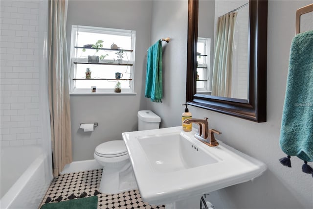 full bathroom with sink, a wealth of natural light, shower / bathtub combination with curtain, and toilet