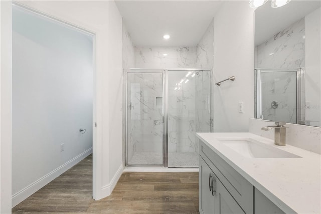 bathroom featuring wood-type flooring, an enclosed shower, and vanity