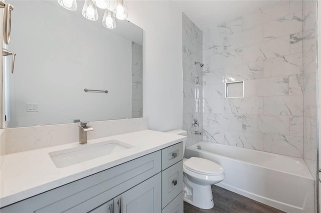 full bathroom with wood-type flooring, toilet, tiled shower / bath combo, and vanity