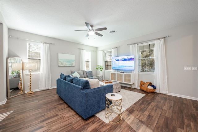 living room with ceiling fan, dark hardwood / wood-style floors, and a textured ceiling