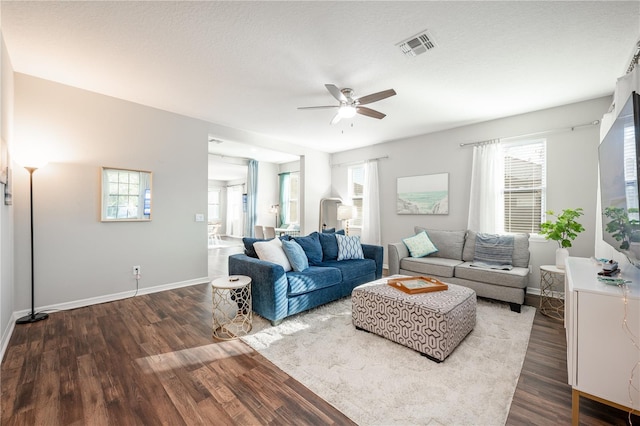 living room with ceiling fan, a healthy amount of sunlight, dark hardwood / wood-style flooring, and a textured ceiling