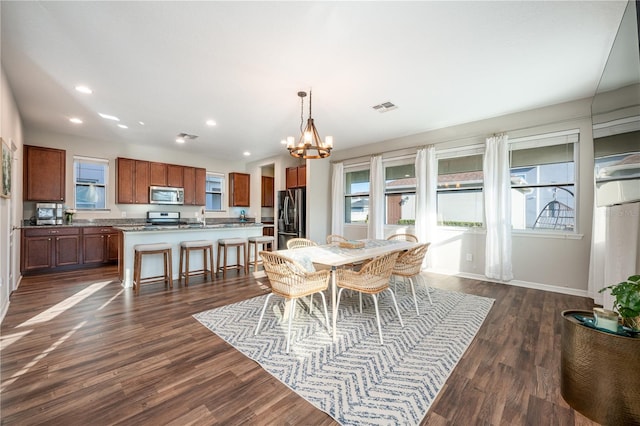 dining room featuring dark hardwood / wood-style flooring, sink, and a notable chandelier