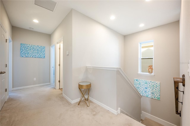 hall with visible vents, an upstairs landing, recessed lighting, carpet, and baseboards