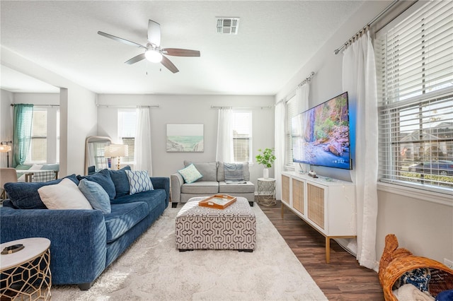 living room featuring visible vents, a healthy amount of sunlight, a ceiling fan, and wood finished floors