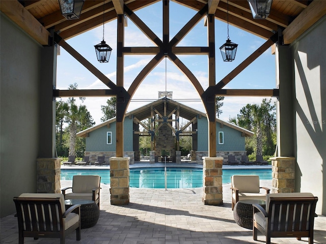 outdoor pool with glass enclosure and a patio