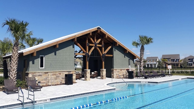 pool with a patio area and fence