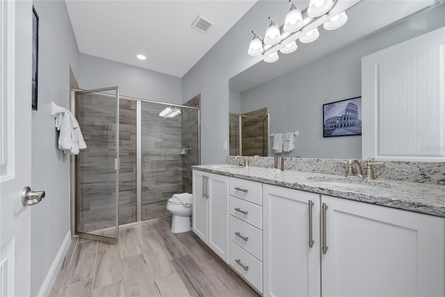 bathroom featuring walk in shower, vanity, toilet, and an inviting chandelier