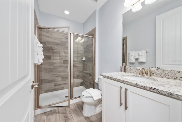 bathroom with walk in shower, vanity, and toilet