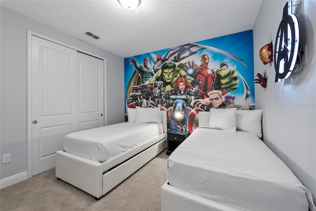 bedroom with light colored carpet, a closet, and a textured ceiling