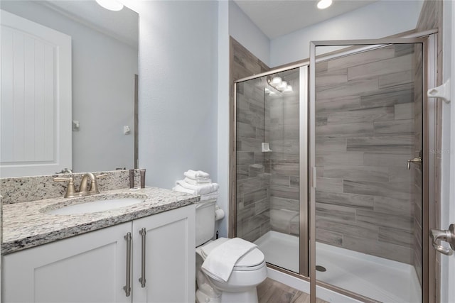 bathroom with vanity, an enclosed shower, and toilet