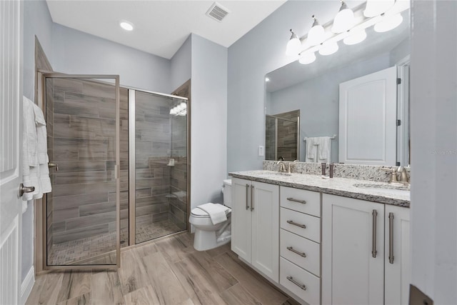 bathroom featuring walk in shower, vanity, and toilet