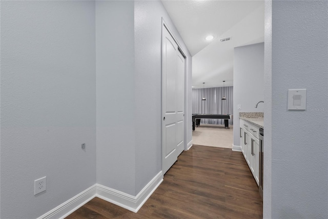 corridor featuring dark hardwood / wood-style flooring and vaulted ceiling