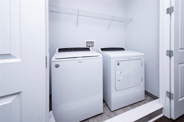 clothes washing area featuring washer and dryer and light parquet floors