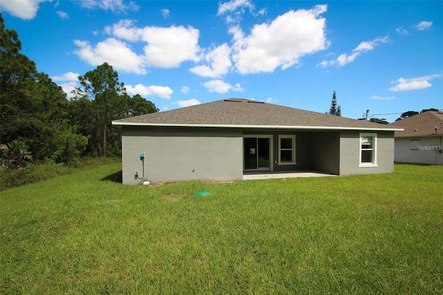 rear view of property featuring a patio area and a lawn