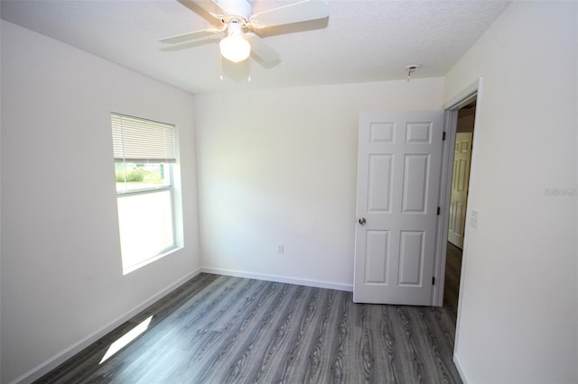 unfurnished room featuring dark wood-type flooring, ceiling fan, and a textured ceiling