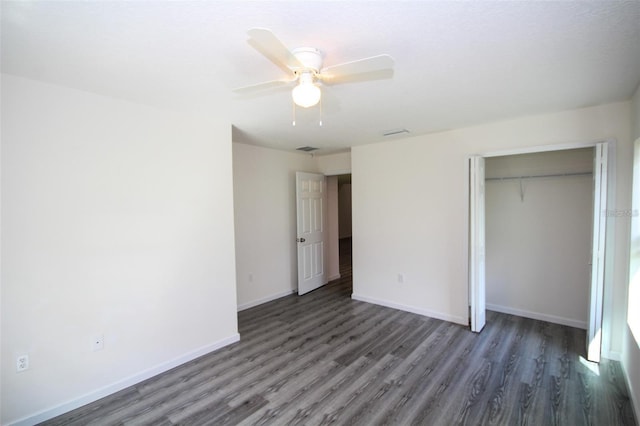 unfurnished bedroom with dark wood-type flooring, ceiling fan, and a closet