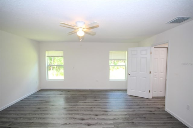 unfurnished room featuring dark wood-type flooring and ceiling fan