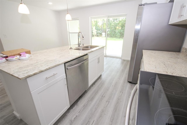 kitchen featuring pendant lighting, white cabinetry, sink, stainless steel appliances, and light stone countertops