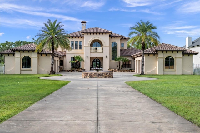 mediterranean / spanish-style house featuring a balcony and a front yard