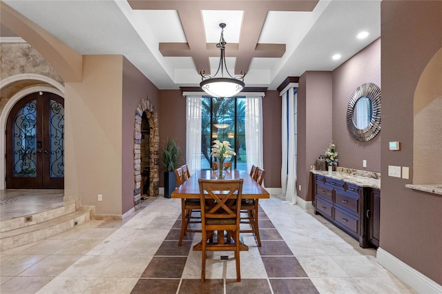 dining space with french doors, coffered ceiling, and light tile patterned floors