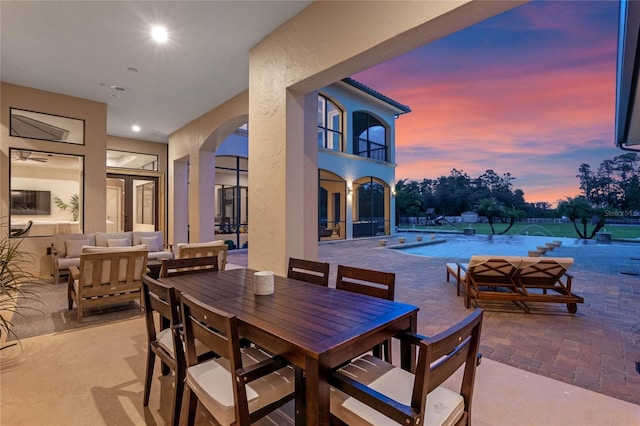 patio terrace at dusk featuring a balcony and an outdoor hangout area