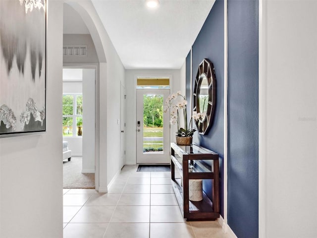 entryway with light tile patterned floors and a wealth of natural light