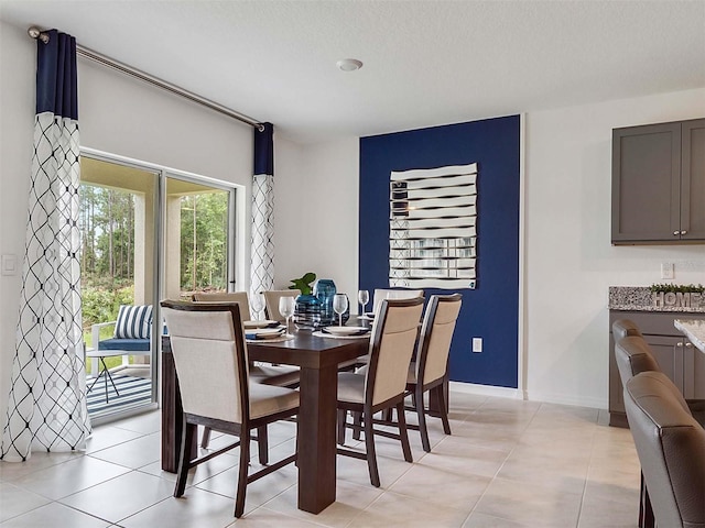 dining area featuring light tile patterned floors and a textured ceiling