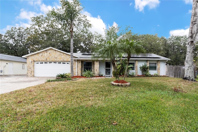 single story home with a garage, a front lawn, and solar panels