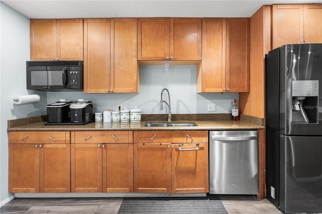 kitchen with sink, light wood-type flooring, and appliances with stainless steel finishes