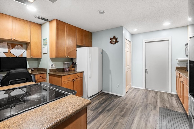 kitchen featuring white refrigerator, dark hardwood / wood-style flooring, range, and a textured ceiling