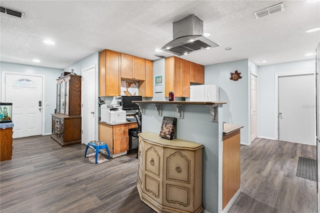 kitchen with a textured ceiling, white refrigerator, dark hardwood / wood-style floors, a kitchen breakfast bar, and island exhaust hood