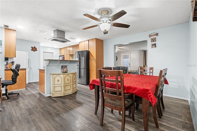 dining space featuring dark wood-type flooring, ceiling fan, and a textured ceiling