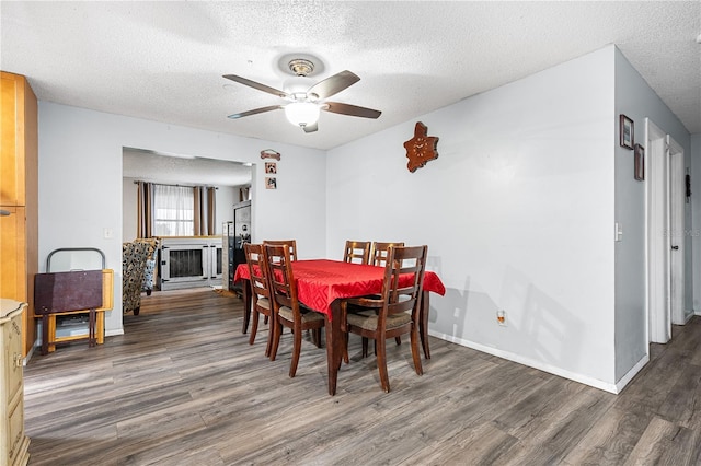 dining space with ceiling fan, dark hardwood / wood-style floors, and a textured ceiling