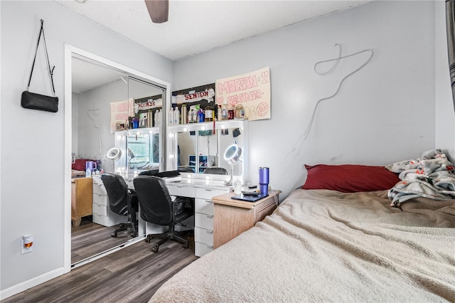 bedroom featuring dark wood-type flooring, ceiling fan, and a closet