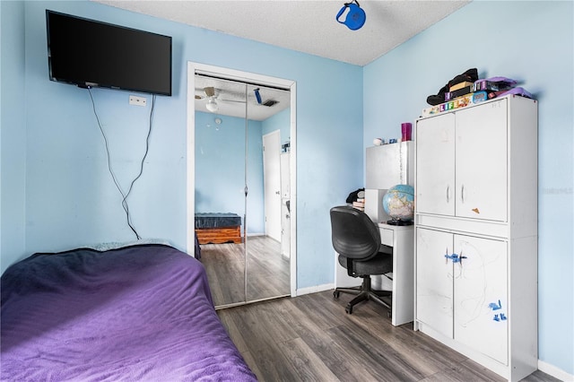 bedroom with a closet, hardwood / wood-style floors, and a textured ceiling