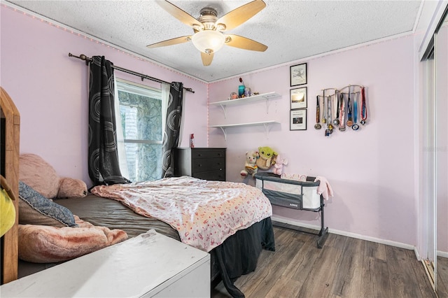 bedroom featuring ceiling fan, wood-type flooring, a closet, and a textured ceiling