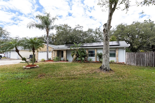 ranch-style home featuring a garage, a front yard, and solar panels