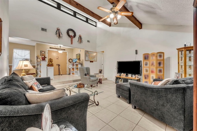 living area featuring visible vents, ceiling fan, beamed ceiling, a textured ceiling, and light tile patterned flooring