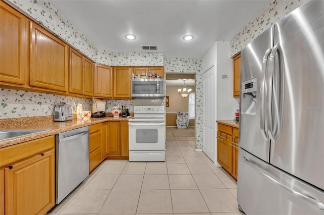 kitchen with a notable chandelier, light tile patterned floors, visible vents, appliances with stainless steel finishes, and a sink