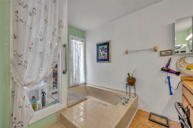 full bathroom featuring tiled bath, a wealth of natural light, vanity, and tile patterned floors