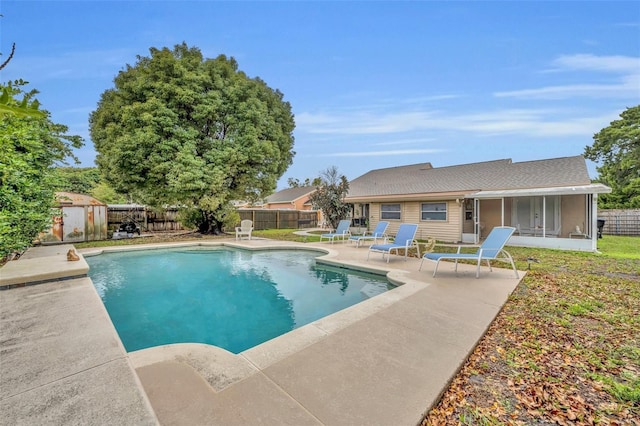 view of pool featuring a storage shed, a fenced in pool, a patio, a sunroom, and a fenced backyard