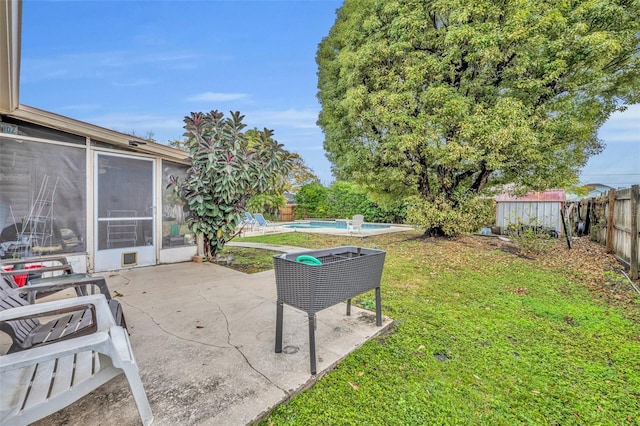 view of yard featuring a patio area, a fenced backyard, a fenced in pool, and a sunroom