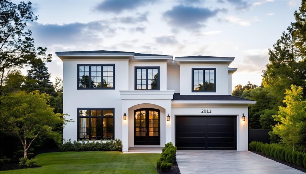 view of front of house with french doors, a garage, and a front lawn