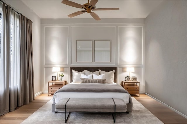 bedroom featuring multiple windows, light hardwood / wood-style flooring, and ceiling fan